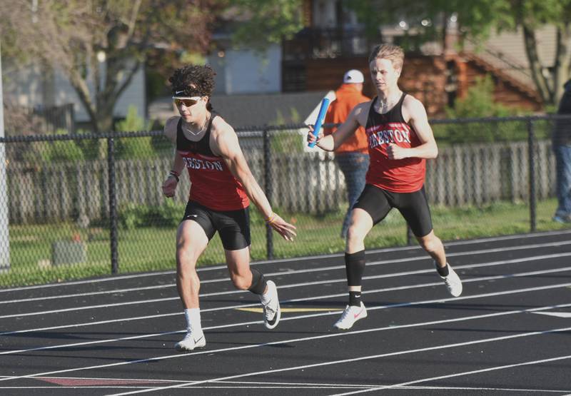 Casen Dryden passes the baton to Seth Gordon in the distance medley relay. The team won the race with a 3:39.7 to advance to state.