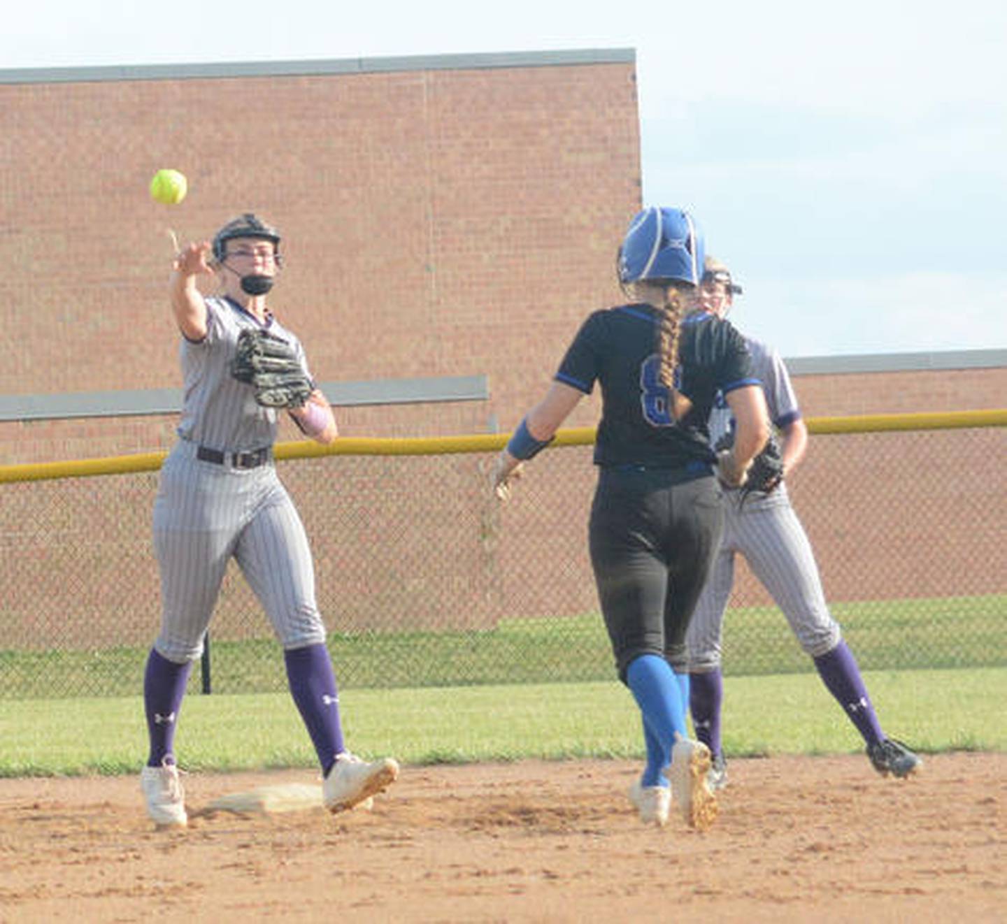 Nodaway Valley's Lindsey Davis, left, darts a throw across the softball diamond during a 2023 playoff game at CAM.