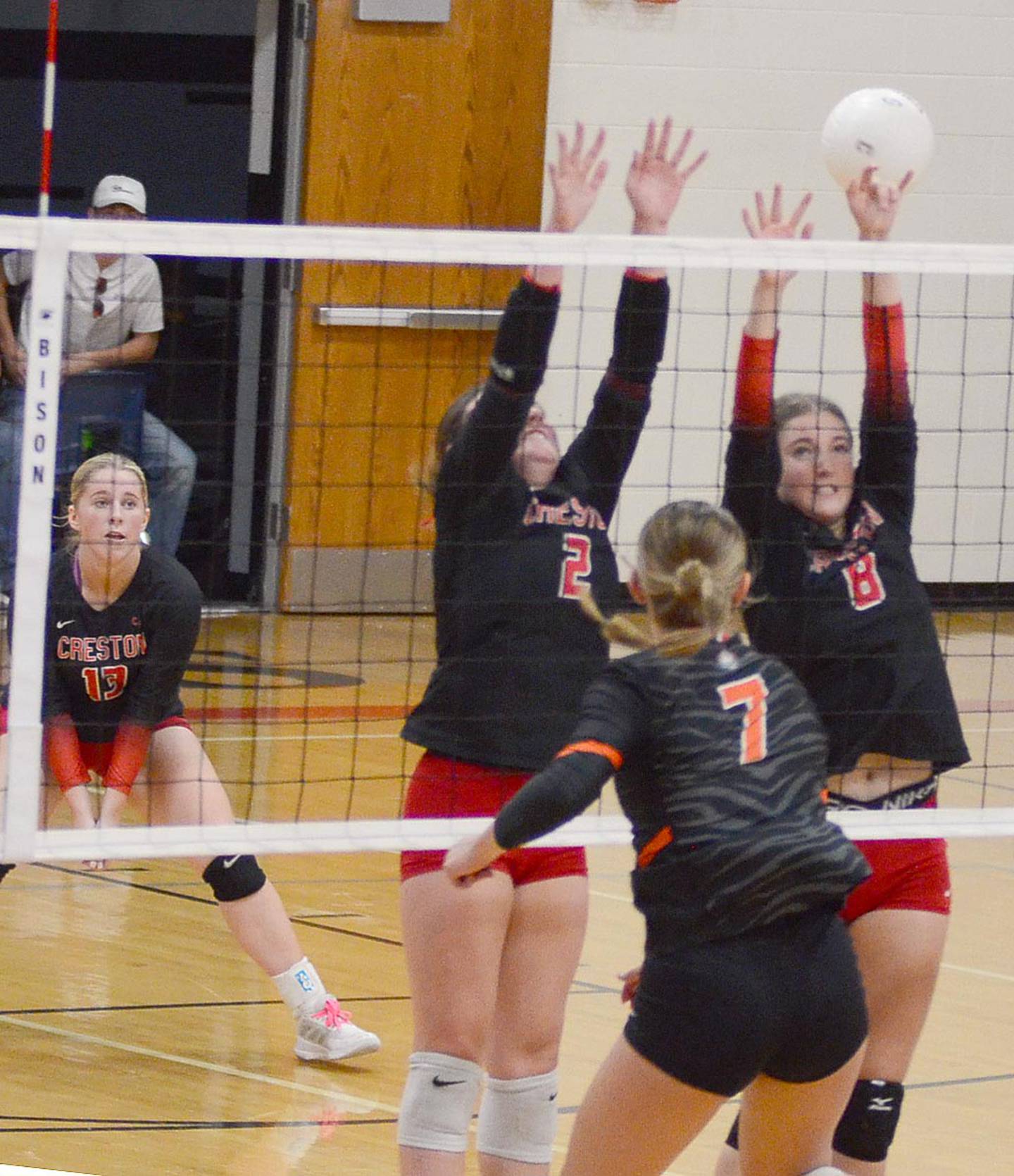 Red Oak's Merced Ramirez (7) hits against the block attempt of Creston's Hollyn Rieck (2) and Ady Morrison (8) during Thursday's match.