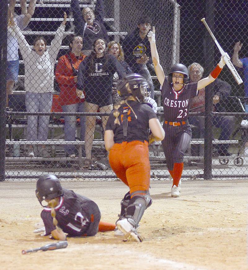 Creston on-deck batter Avery Staver (23) celebrates the winning run scored by teammate Sasha Wurster (12) on Ava Adamson's double in the ninth inning for a 6-5 victory over Earlham in the John Stephens Classic.