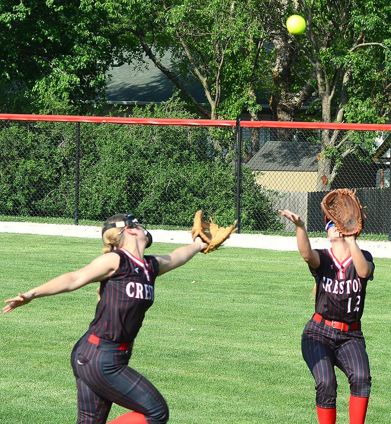 Creston right fielder Sasha Wurster (12) prepares to make the catch as second baseman Sophia Hagle hustles toward the play during Monday's opener against Ames.