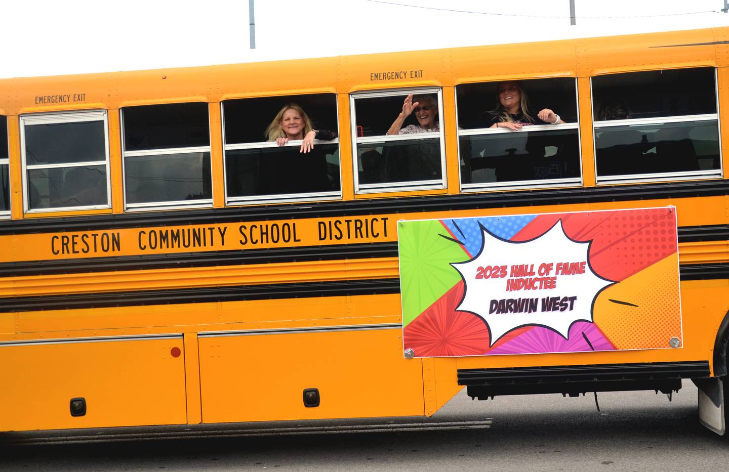 The family of Darwin West waves to the crowd from a school bus during Friday's homecoming parade.