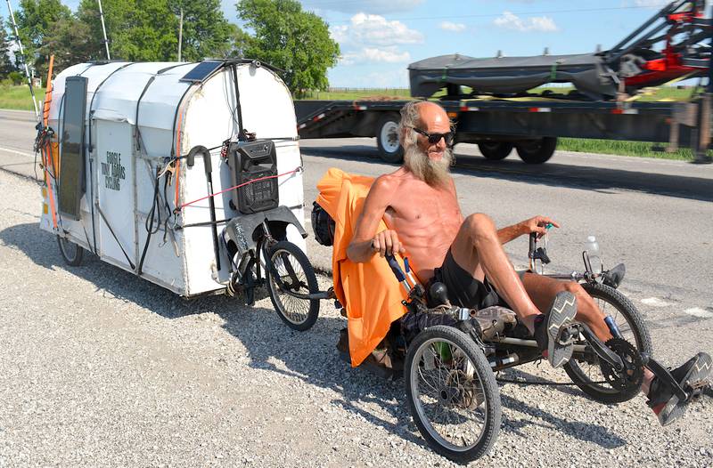 Tony Adams and his trailer pedals west on Highway 34 just outside of Creston. The 700 lbs trailer, which Adams calls his "house," contains all of his belongings.
