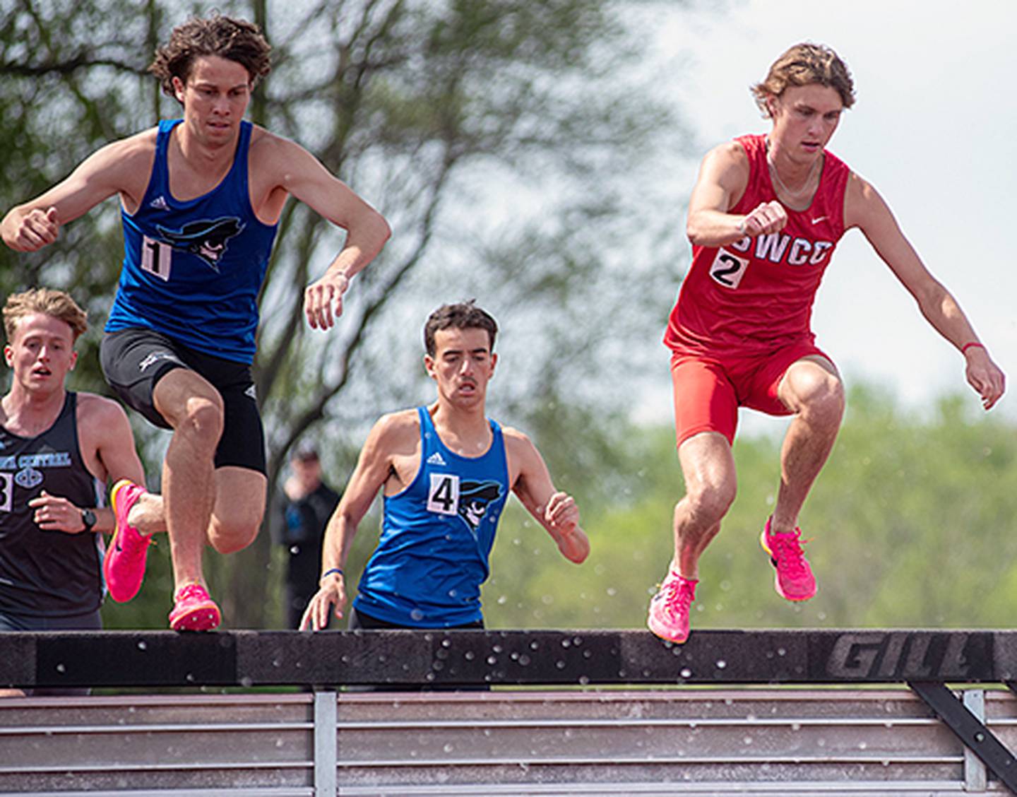 Southwestern's Chase Oates (right) clears a hurdle during the 3,000-meter steeplechase at the regional meet in Council Bluffs. Oates won the race in 9:37.59.