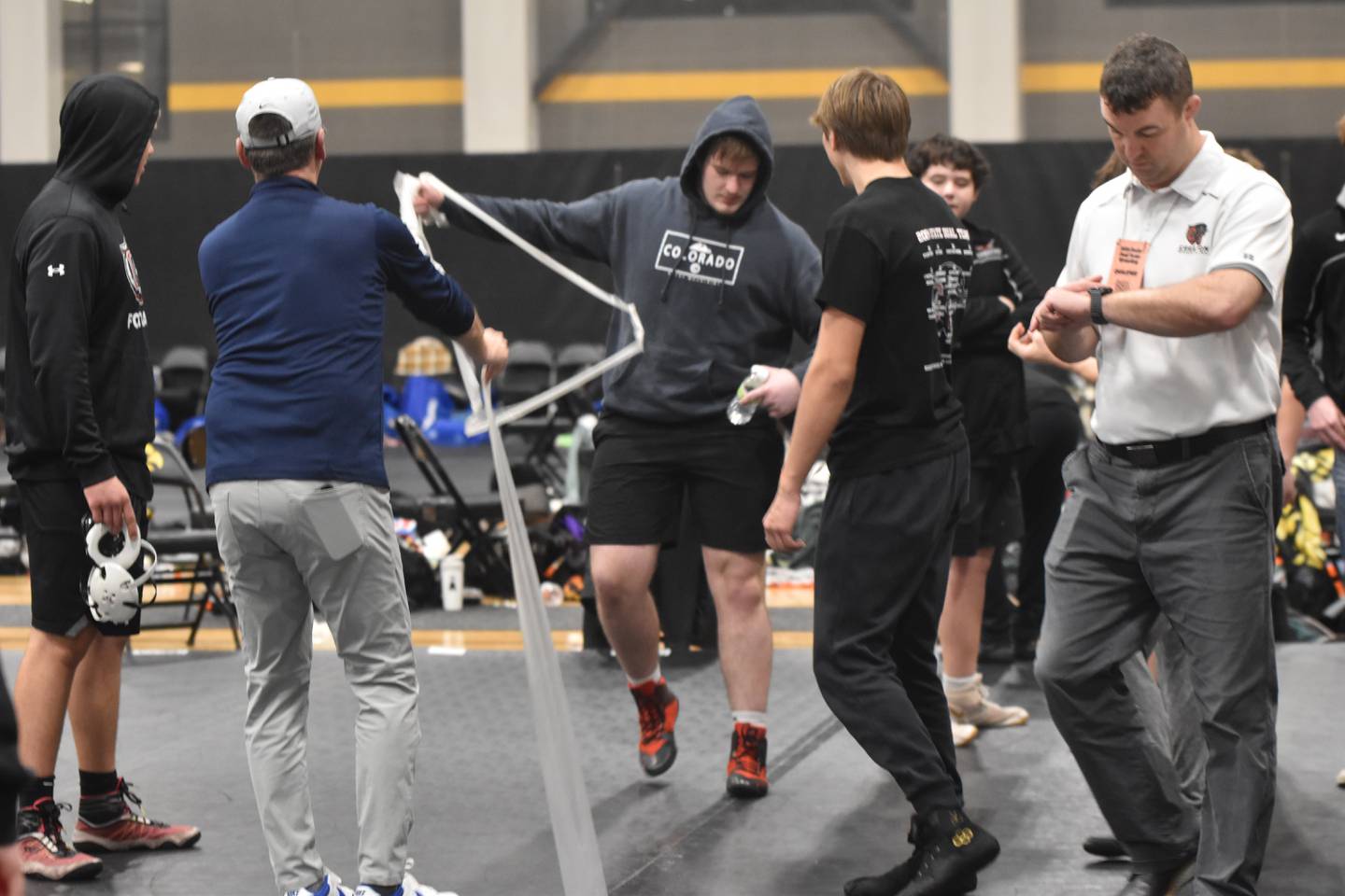 Wrestlers help employees tear down the mats before the finals.