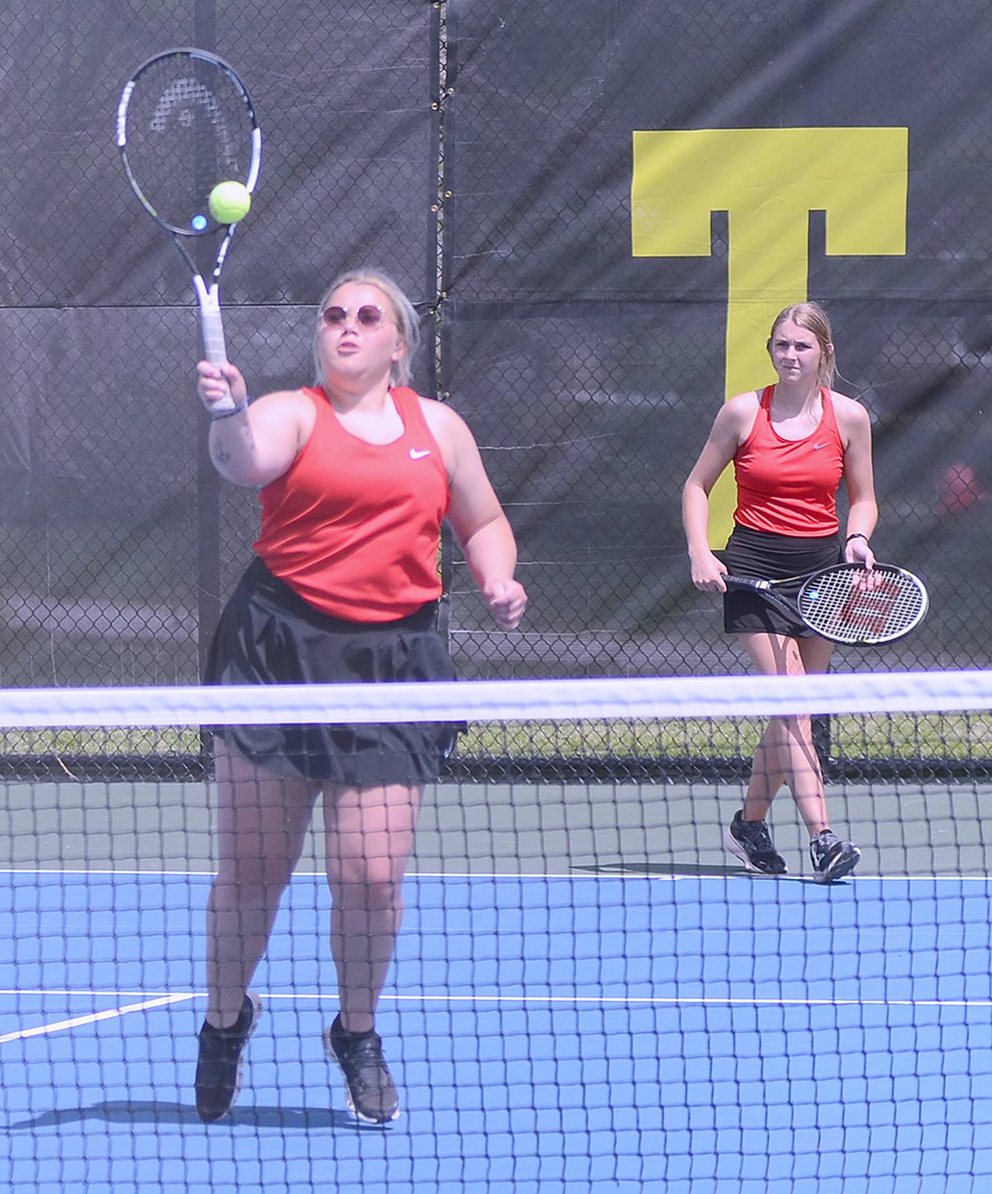 Abbie Wheeler of Creston hits a shot at the net as doubles teammate Kolbey Bailey covers the baseline during their match against Atlantic Friday.