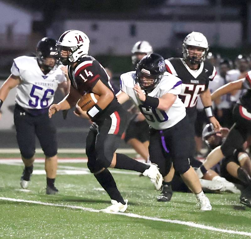 Nodaway Valley/OM senior lineman Charles Rudolf (60) gives chase to Mount Ary's Tyler Martin (14) in the Battle for the Rock game Friday, Aug. 30, which the Raiders won 58-6.