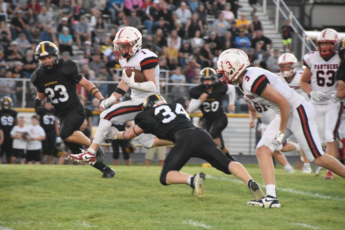 Weston Trapp hurdles a tackle attempt by Winterset’s Kahne Kiburz as Parker Varner (No. 3) comes in to help. Trapp led the offense with 107 rushing yards and 21 receiving yards.