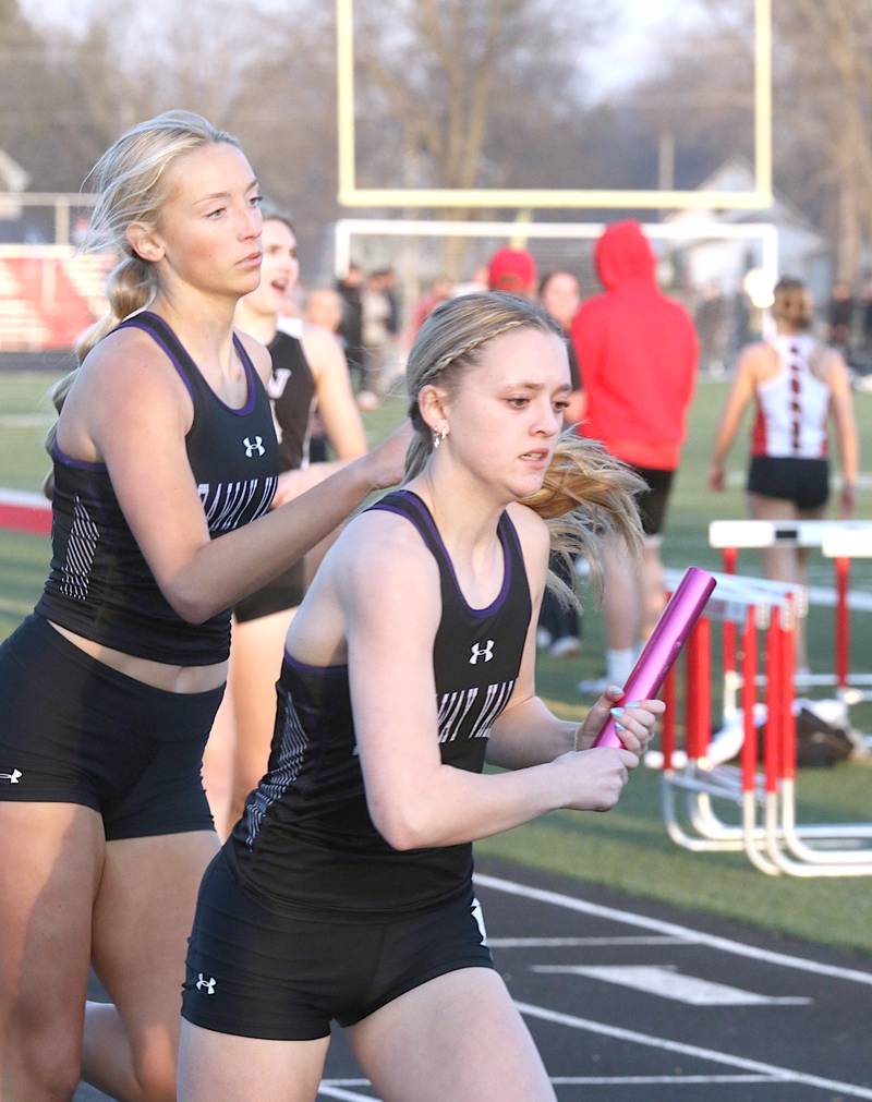 Nodaway Valley's Maddie Weston (right) takes the baton from Izzy Eisbach in a relay race in Earlham Thursday, March 28.