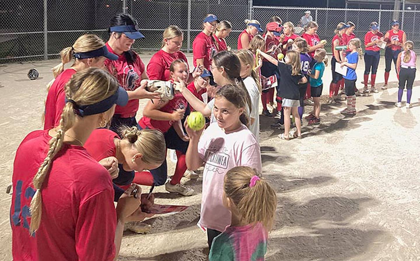 Southwestern softball players sign autographs for participants in Monday's youth camp held at Murray Little League fields.