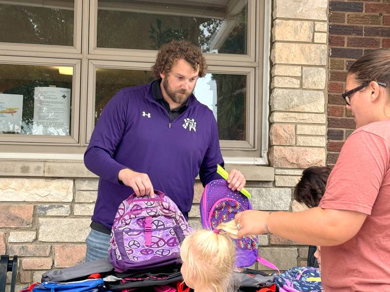 NV Elementary Principal James Larson shows students available backpacks at a school supply drive on the Greenfield Public Square Monday, Aug. 12.