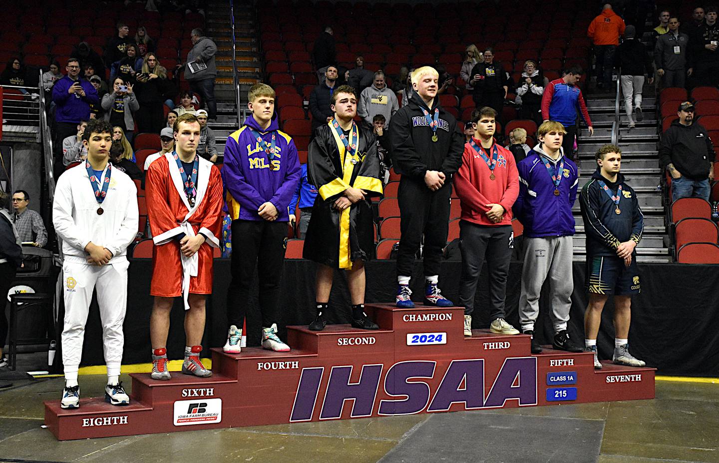 Nodaway Valley/OM's Ashton Honnold stands on top of the medal stand with seven other medalists at 215 pounds.