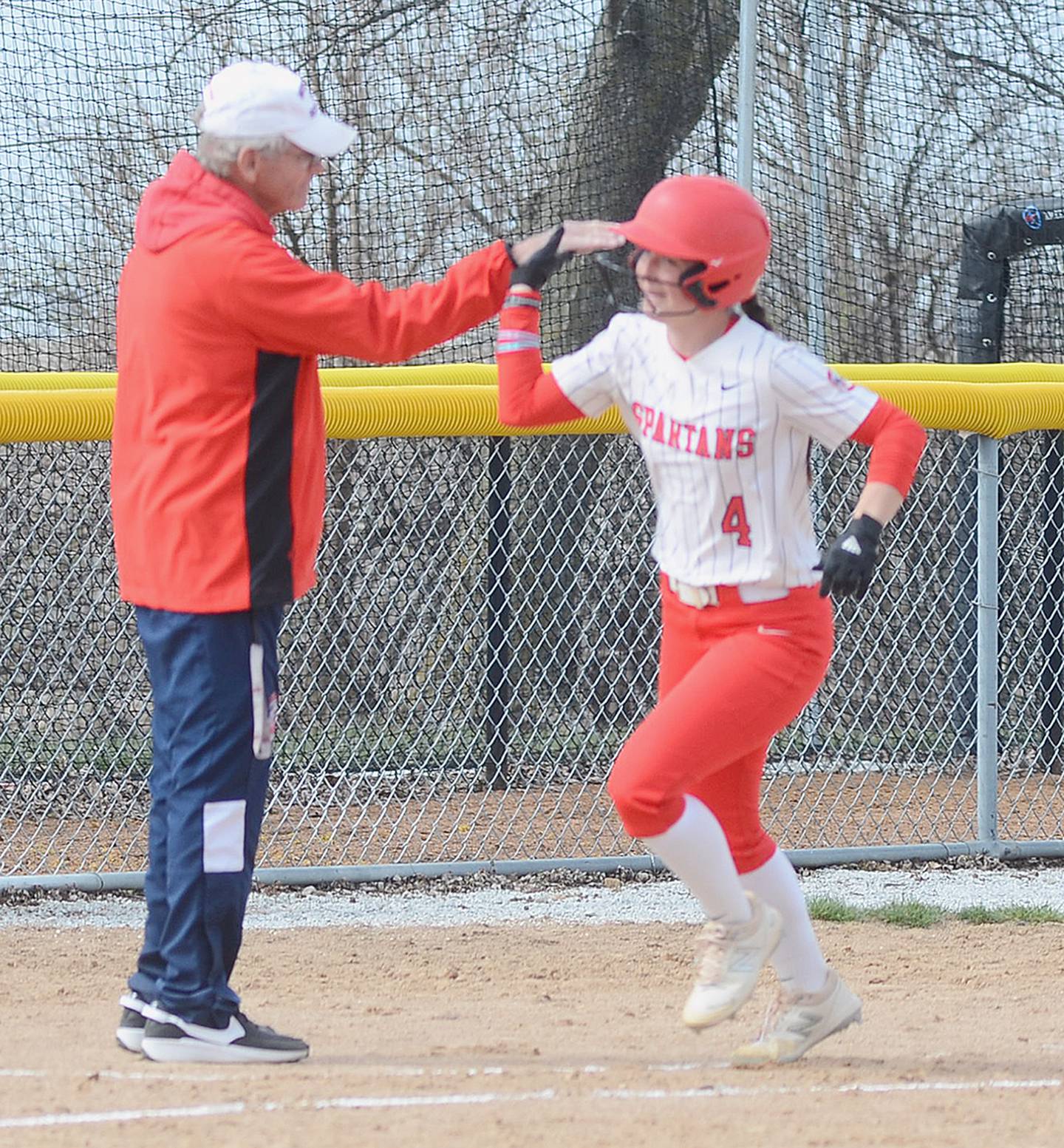Southwestern coach Danny Jensen gives a "high five" to third baseman Ashton Willis (4) after her two-run home run in the seventh inning of Friday's 7-5 loss to Marshalltown. Willis had five hits in the two games.
