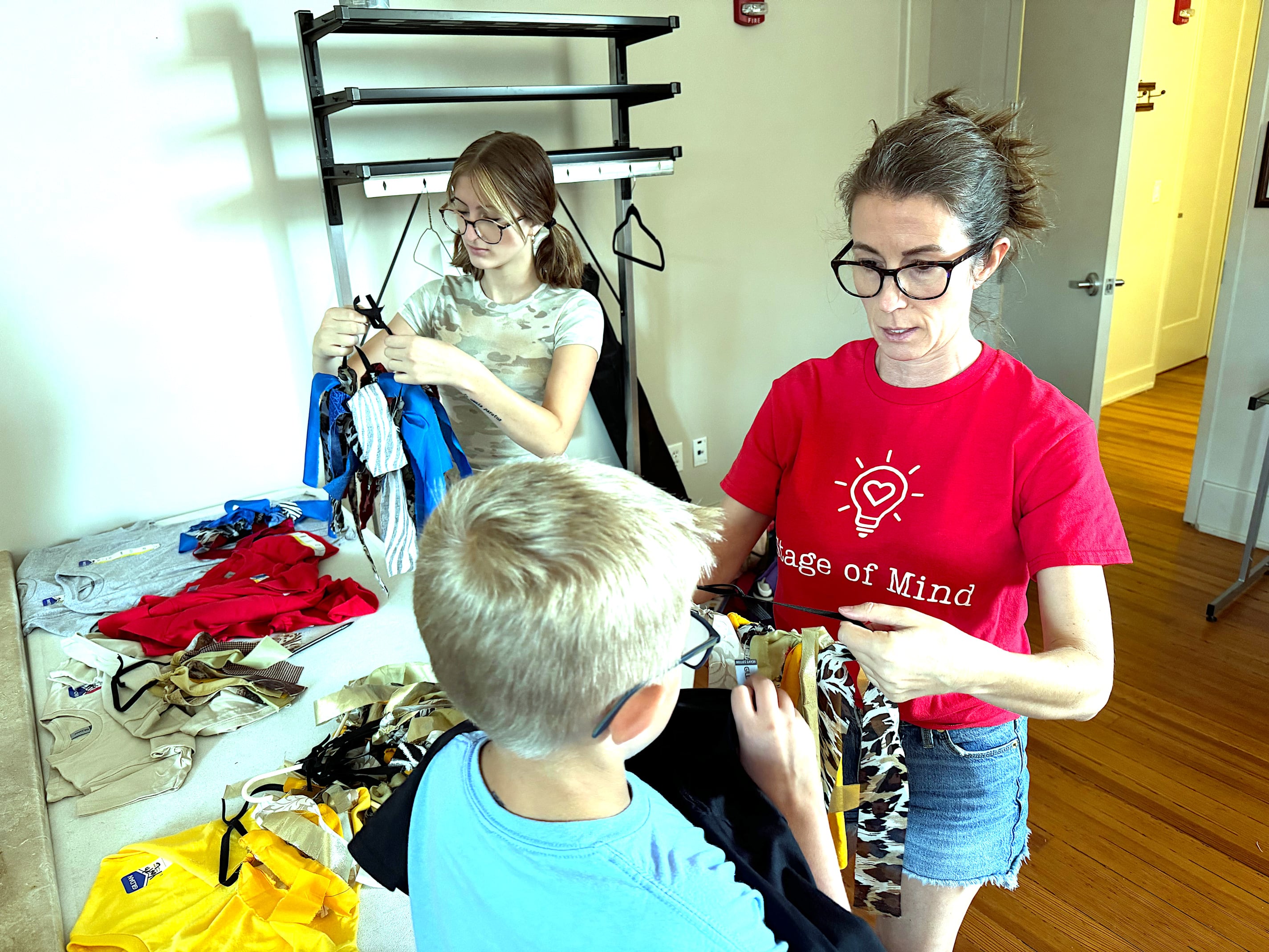 Sarah Smith Burke (right) and daughter Taylor Burke (left) help campers prepare for rehearsal of "Lion King Kids" last week at the Warren Cultural Center.