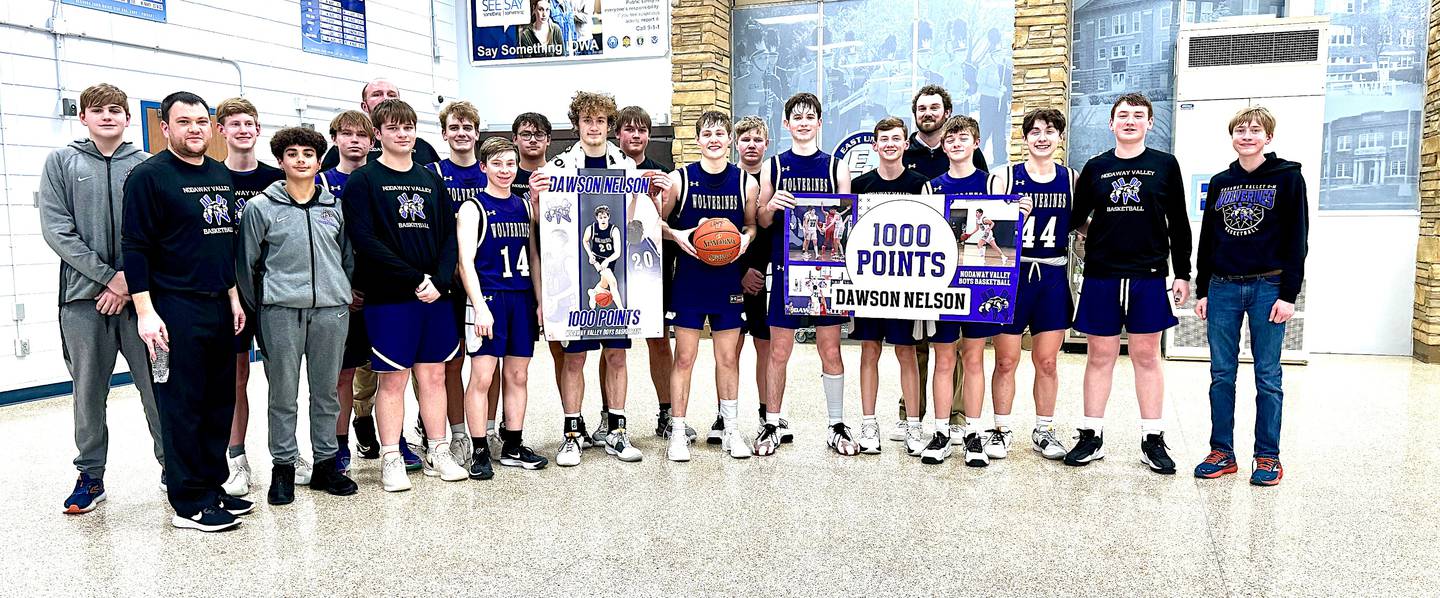 NV senior Dawson Nelson (middle, with the ball) celebrates with his teammates and coaches reaching 1,000 career points in a playoff win Friday over East Union. He is the son of Curtis and Ashlee Nelson.