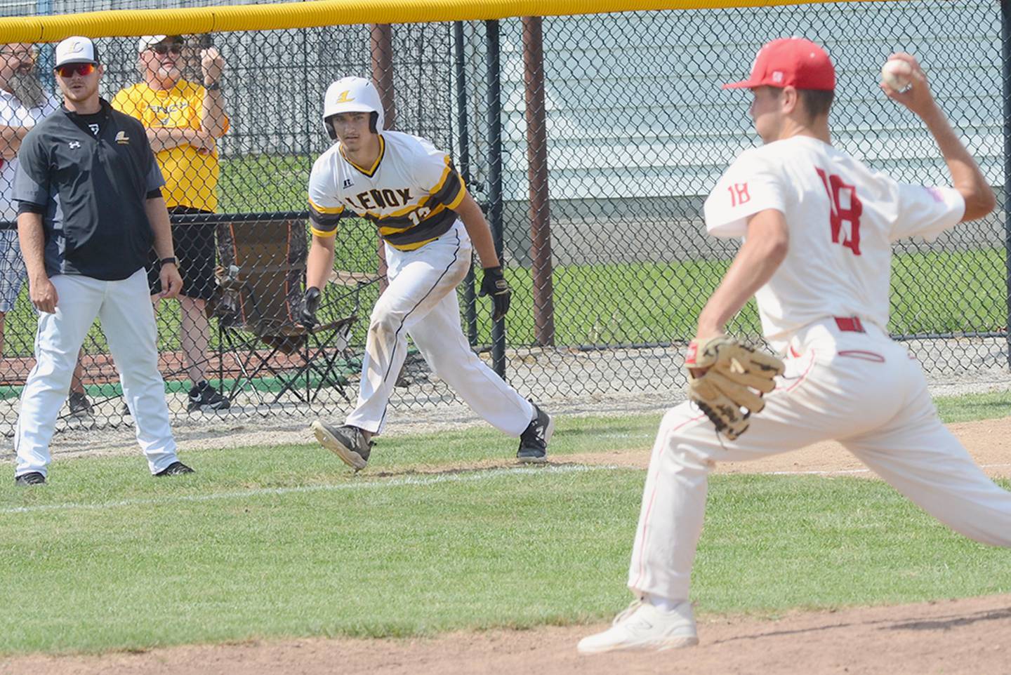 Brody Brokaw of Lenox takes a lead off third base in front of head coach Trevor Luther during Saturday's district tournament win. Moments later Brokaw scampered home on a passed ball for the final run of the 10-0 victory.