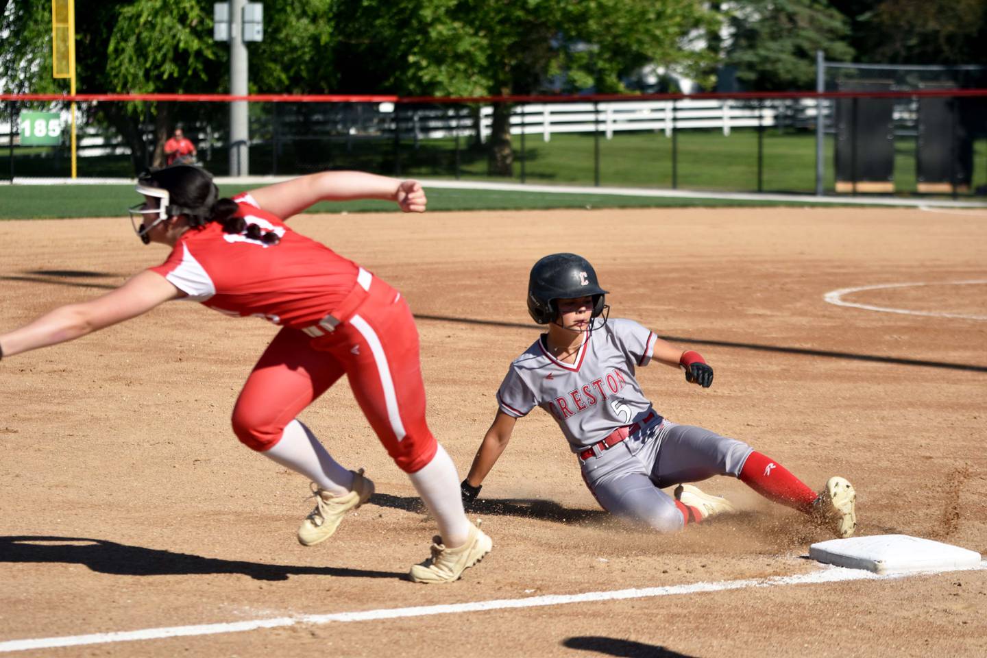 Ava Adamson slides safely into third base for a triple to open the game.